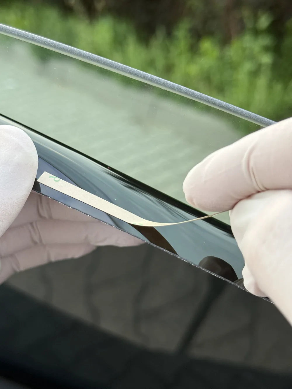 Transparante 3M-tapestrips op de rand van het paneel kleven